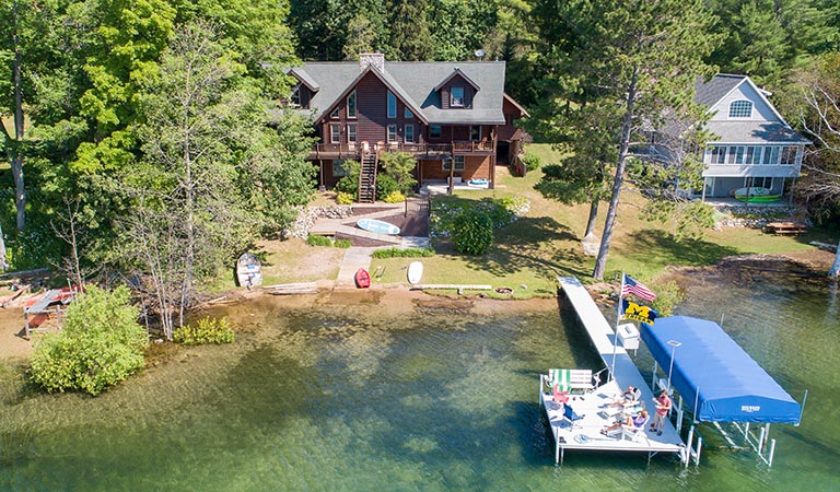 Aerial view of a lake house and dock